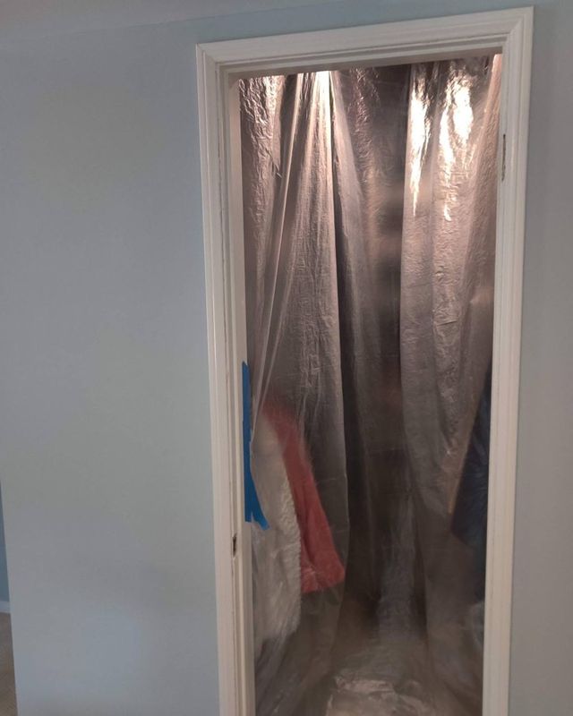Walk-in closet doorway with no door, covered in plastic sheeting