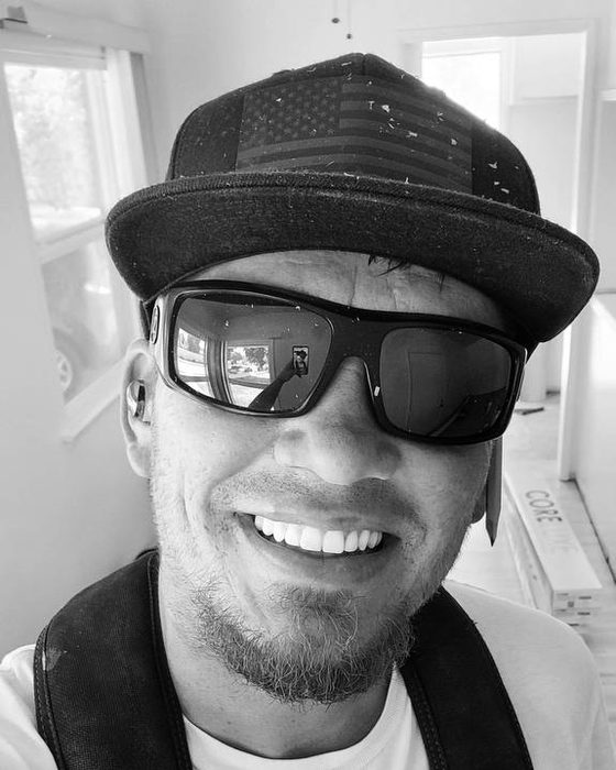 Justin Ellsworth, owner of Honey Do List Specialist, smiling in a cap and sunglasses